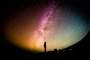 Man standing alone in front of the galaxy