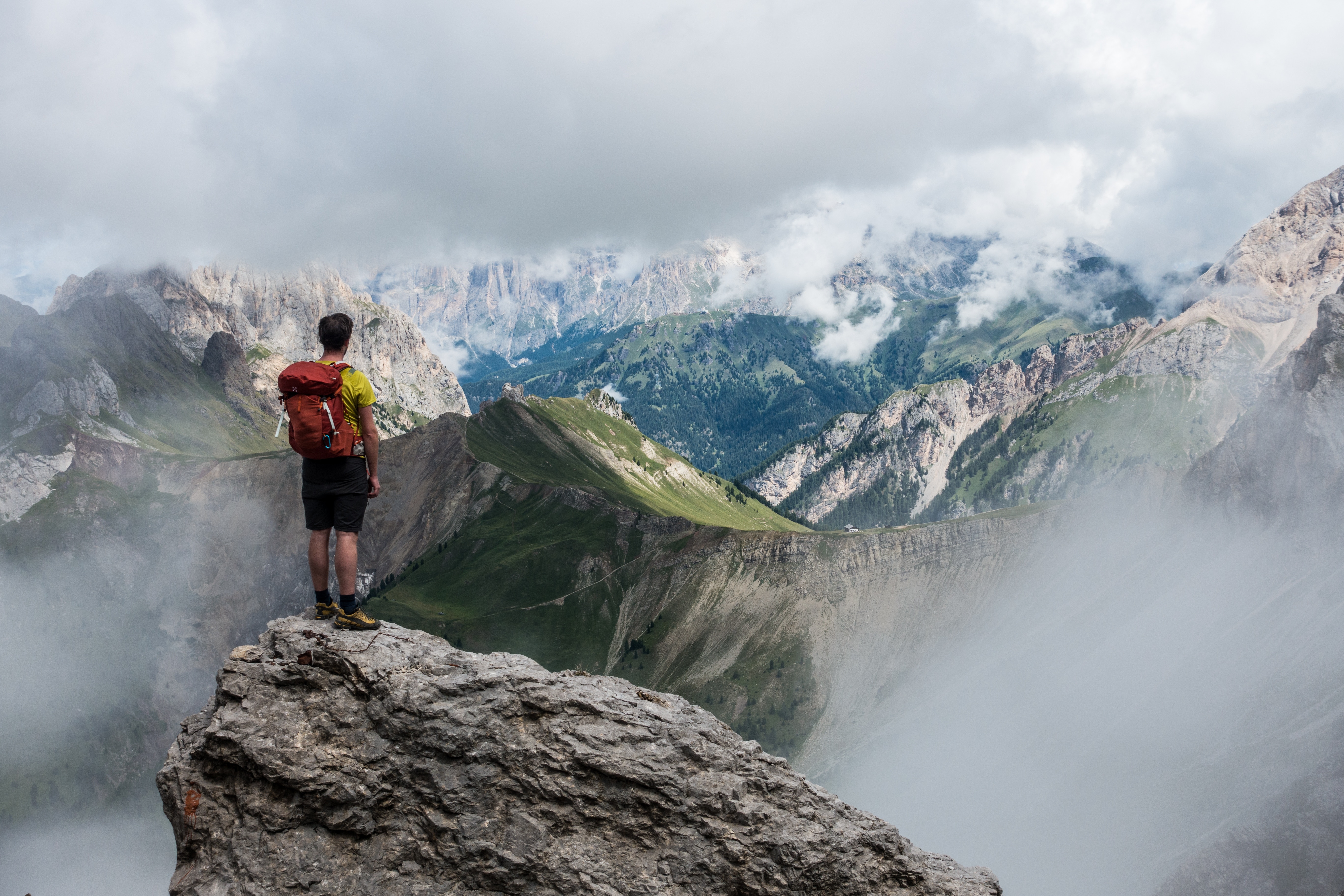Man on ridge staring at top of mountain