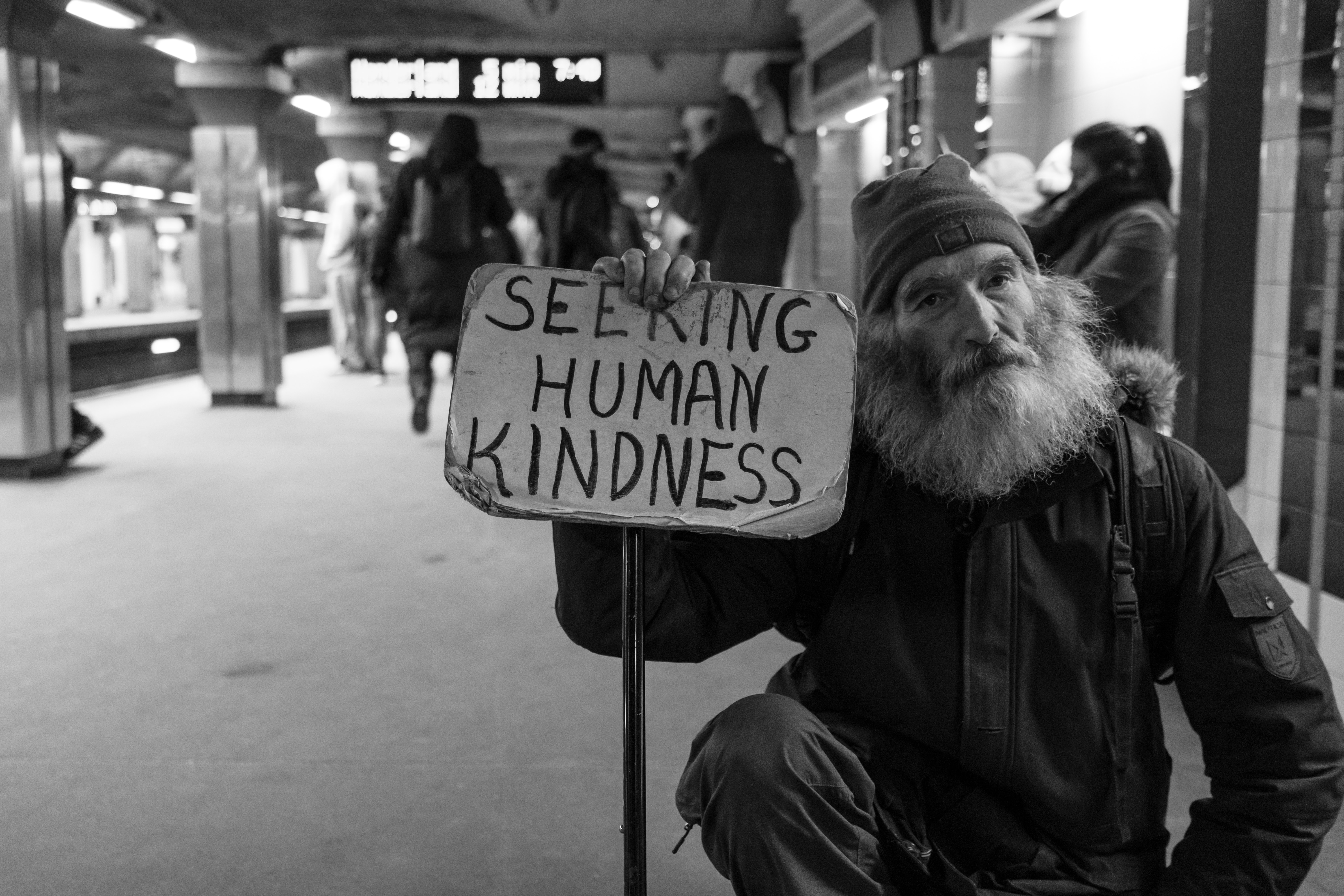 Man holding sign that says, "Seeking human kindness"